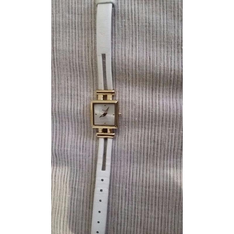 Kenneth Cole women’s watch with thin white leather strap and square face with gold border