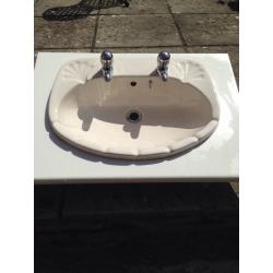 Cream bathroom ceramic basin and taps